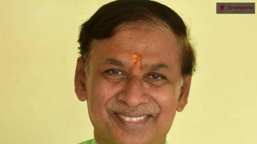 Close-up portrait of an Indian man with a tilak on his forehead, smiling and looking directly at the camera.